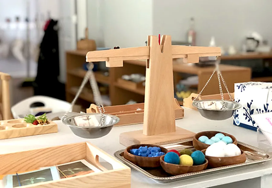 Montessori balance and fine-motor materials on a prepared shelf